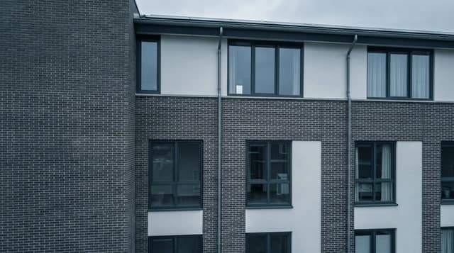 Bakstenen gevel met een cyaan kader om een scheur boven een raamkozijn, zoals Fortica Technics een gebrek markeert in een inspectierapport.